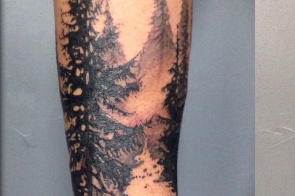 Tatouage realiste d'une foret de sapins par Virginie Tatouage a Strasbourg